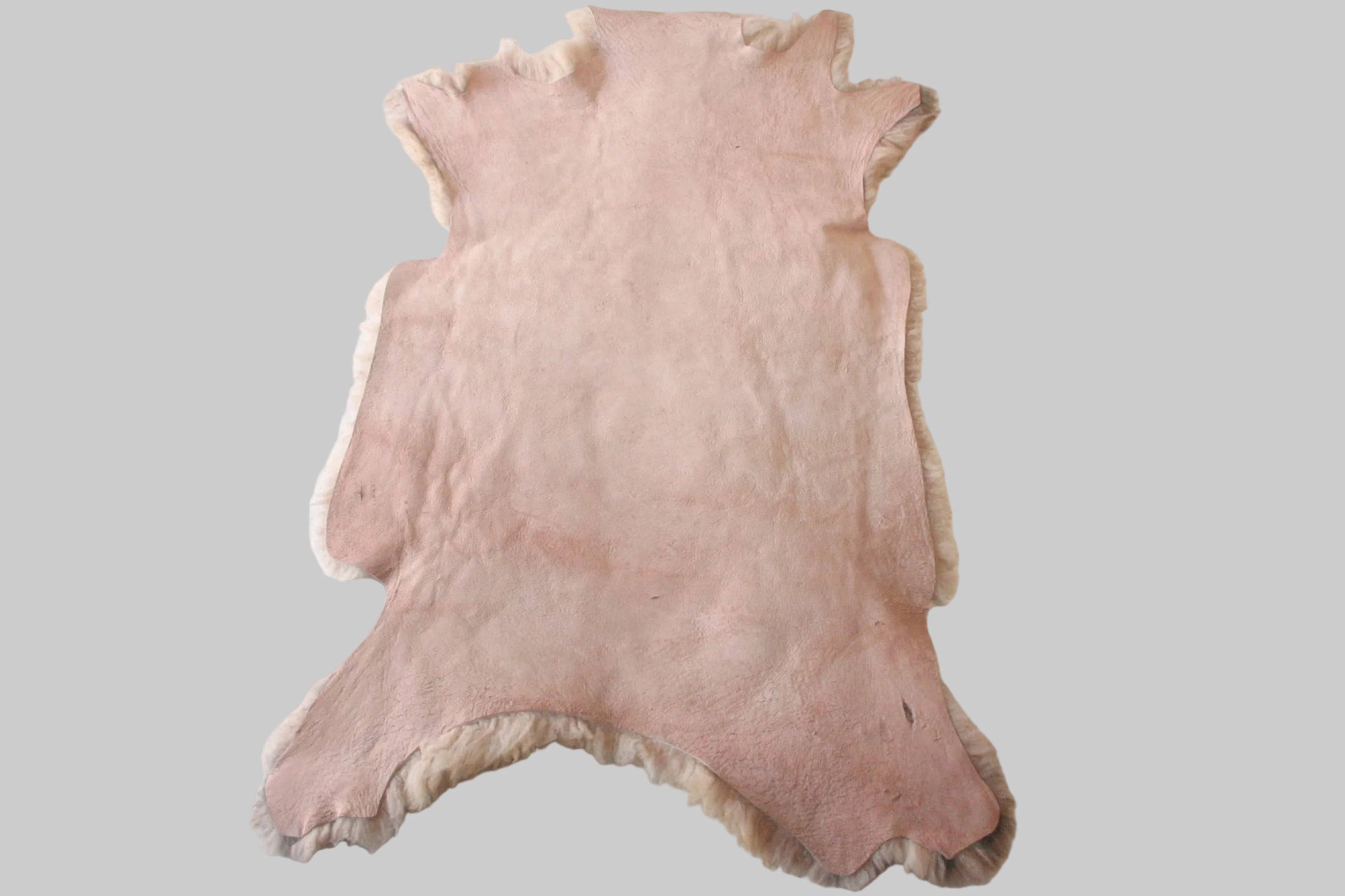 Pink fur rug on a white floor