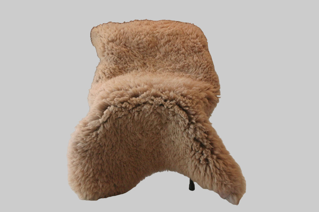 Beige sheepskin chair against a neutral background