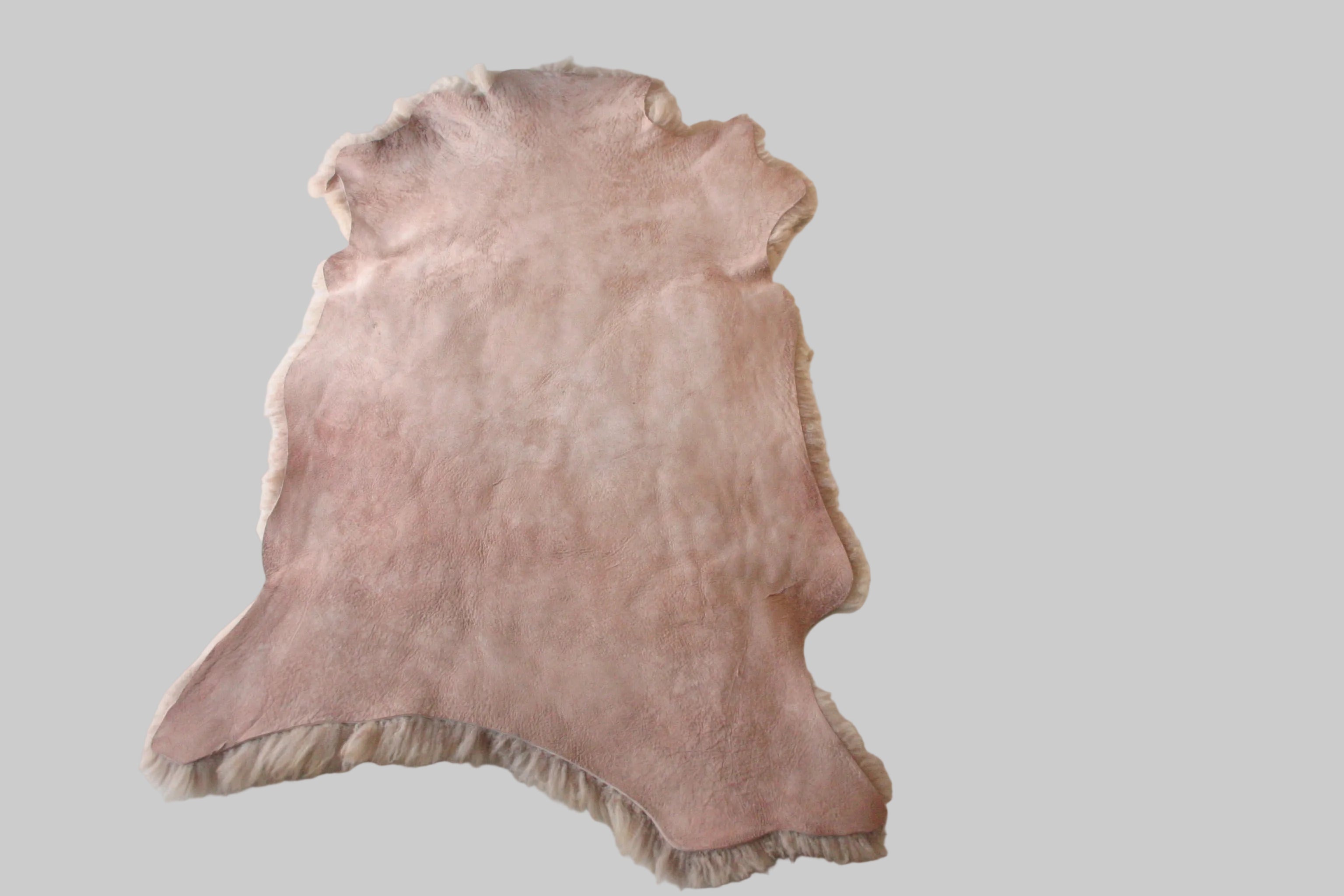 Pink fur rug on a light gray surface